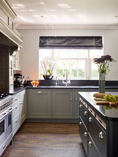 a kitchen with gray cabinets and black counter tops