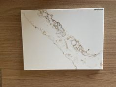 a white marble counter top sitting on top of a wooden table next to a knife