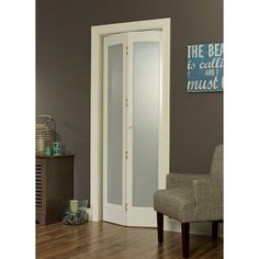 an empty chair sits in front of a white door with glass panels on the side