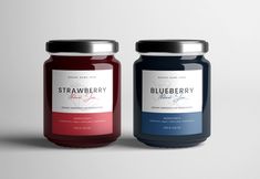 two jars of blueberry and strawberry jam on a grey background with the label removed