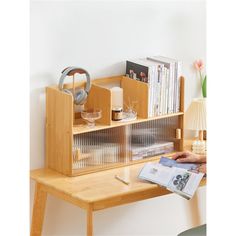 a person is sitting at a desk with a magazine rack and books on top of it