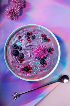 a bowl of food with blueberries, raspberries and sprinkles