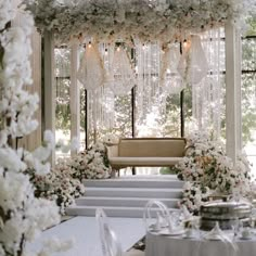 an outdoor wedding setup with white flowers and chandeliers