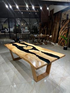 a table made out of wood with black and white designs on the top, sitting in a large room