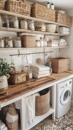 a washer and dryer in a small room with baskets on the shelves above