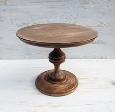 an old wooden cake plate sitting on top of a white table