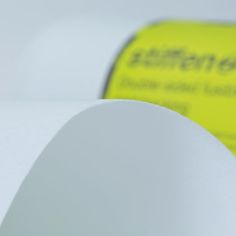 a roll of white paper sitting on top of a table next to a yellow sign