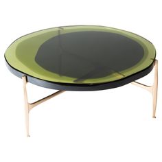 an oval glass table with wooden legs and a black top, on a white background