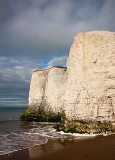 white cliffs on the beach under a cloudy sky