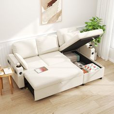 a white sectional sofa with pull out bed and storage compartment underneath it in a living room