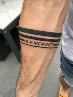 a man's arm with a black and white tattoo that reads, i v mcmxxiii