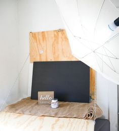 a room with some wood and paint on the floor next to a blackboard that says hello