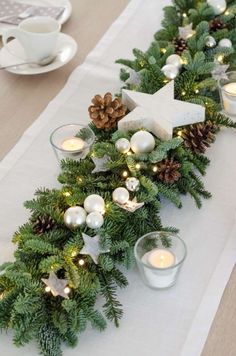 the table is set with candles and pine cones