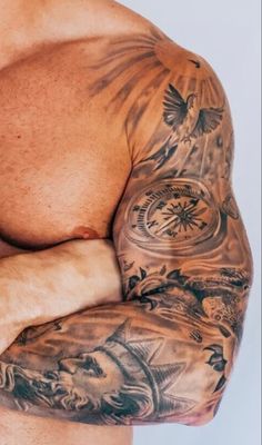 a man with tattoos on his arms and chest is looking at the camera while holding his hands behind his back