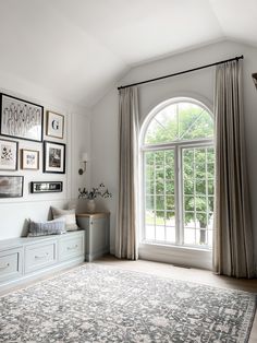 a living room filled with lots of furniture and pictures on the wall next to a large window