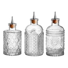 three clear glass bottles with wooden lids