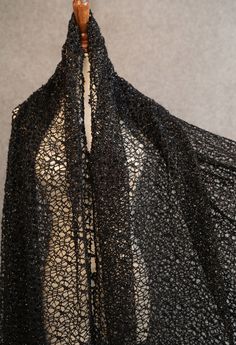 a piece of black lacy fabric on a mannequin dummy with a wooden stick sticking out of it