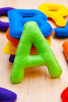 colorful felt letters sitting on top of a wooden table