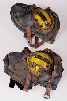 two helmets with yellow and black paint on them, one is worn as a helmet