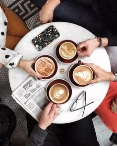 people sitting at a table with cups of coffee