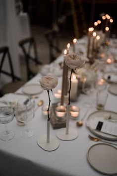 a long table is set with candles and place settings for an elegant dinner or party