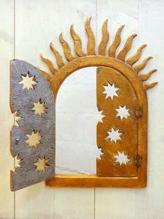 a mirror that is on the wall next to a wooden frame with sun and moon designs