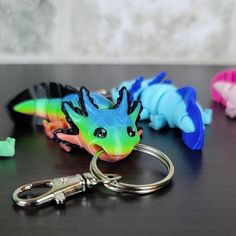 three different colored plastic key chains sitting on top of a black table next to each other