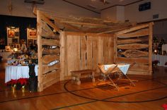 a room with wooden walls and wood flooring, decorated in white cloth draped over the table