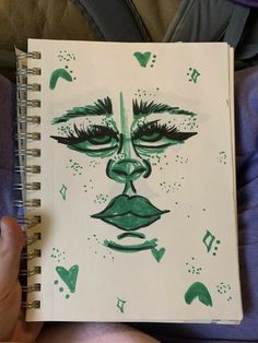 a drawing of a woman's face is shown in green ink on a white paper