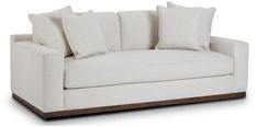 a white couch with four pillows on it's back and two side tables in front