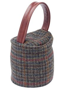 a brown and blue tweed basket with leather handles on a white background for use as a storage container