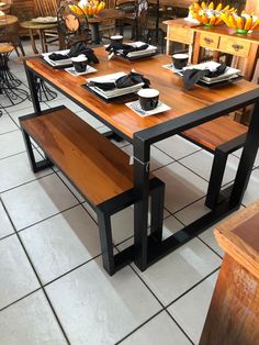 a wooden table with two benches in front of it and vases on the side