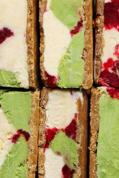 several squares of ice cream with raspberries and green leaves on them are arranged in rows