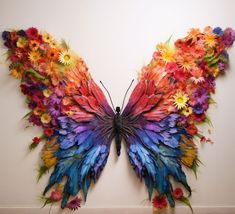 a colorful butterfly made out of flowers on a wall