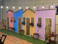 a fake house is on display in a room with artificial grass and potted plants