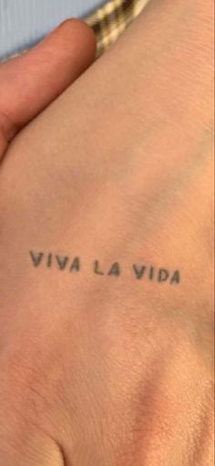 a person with a small tattoo on their left arm and the words viva la vita written in cursive ink