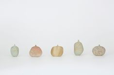 five different colored vases sitting side by side