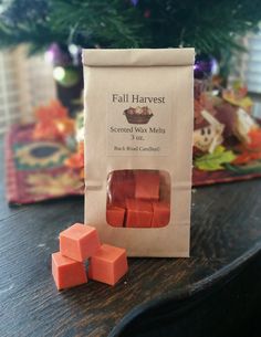 a bag of orange cubes sitting on top of a table next to a christmas tree