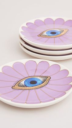 two purple plates with an eye painted on them