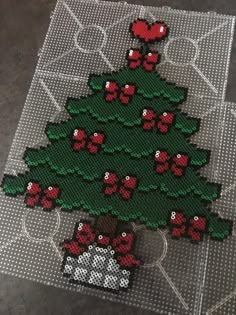 a cross stitch christmas tree with presents on it