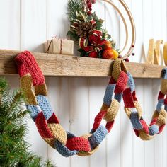 a crocheted christmas wreath hanging from a wooden shelf next to a pine tree