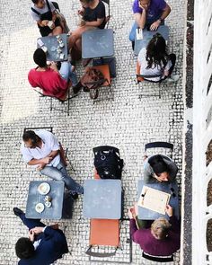 several people sitting at tables with laptops on them