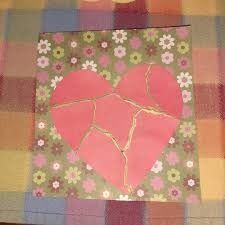 a piece of paper that has been cut into two hearts and is on a checkered table cloth