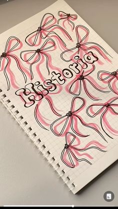 a spiral notebook with pink and black bows on it