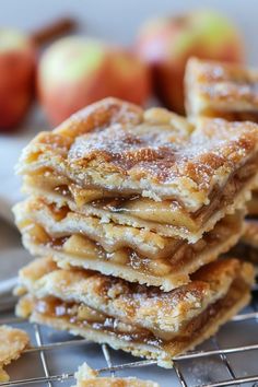 a stack of apple pies sitting on top of a cooling rack