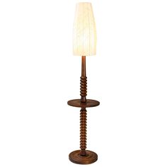 a lamp that is sitting on top of a wooden stand with a white light in the middle