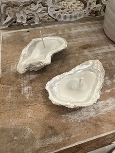 two white oysters sitting on top of a wooden table