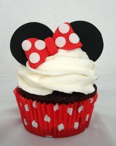 a cupcake with white frosting and minnie mouse ears