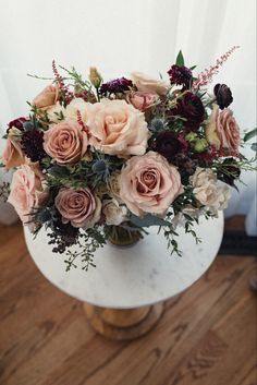 a vase filled with lots of flowers on top of a table