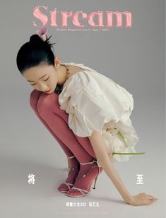 a magazine cover with a young woman in high heels holding a flower and kneeling down